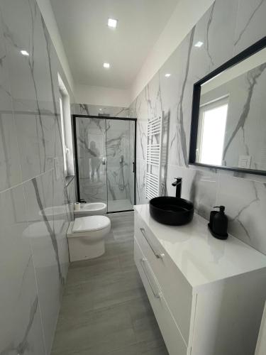 a white bathroom with a toilet and a sink at Villa Costantino Luxury in Pompei