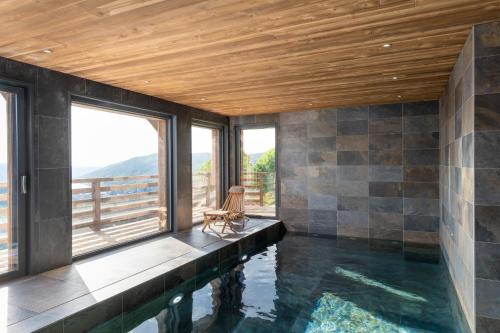 a house with a swimming pool with a wooden ceiling at Aigle des Neiges 5 étoiles in Gérardmer