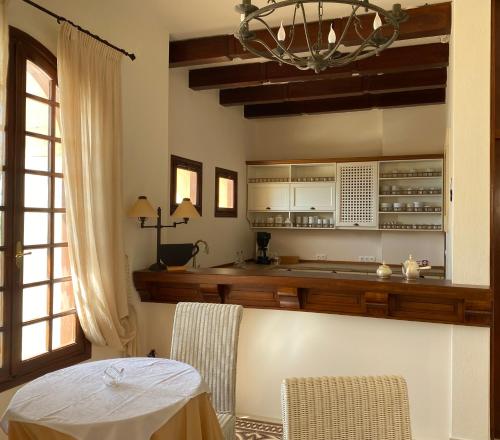 a kitchen with a table and a chandelier at Palazzo Arhontiko Apartments in Agios Nikolaos