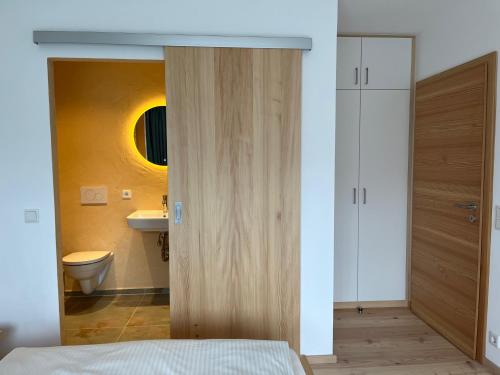 Schlafzimmer mit einer Tür zum Bad in der Unterkunft Seehof Apartments in Walchensee