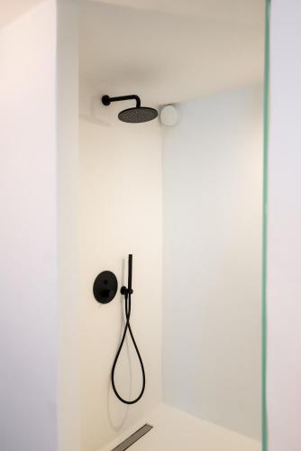 a shower in a white wall with a shower head at Ryous Mykonos in Mýkonos City