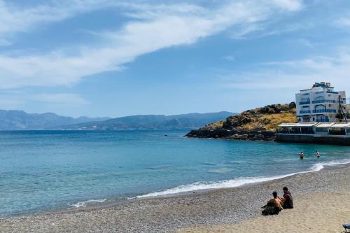 a group of people on a beach near the water at Palazzo Arhontiko Apartments in Agios Nikolaos