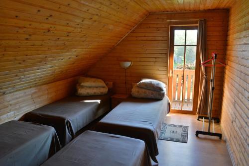 a attic room with two beds and a window at Pie Pētera in Cēsis