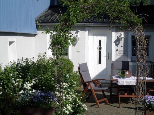un patio con mesa y sillas frente a una casa en Blockstube, en Rammenau