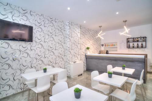 un restaurante con mesas blancas y una pared en Hotel Porto Di Roma en Civitavecchia