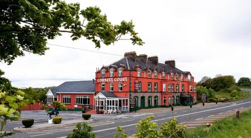 a large red building on the side of a street at Corbett Court in Fermoy