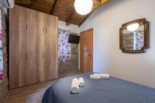 a bedroom with a bed with two towels on it at Ρίζες - Rizes in Repanídhion