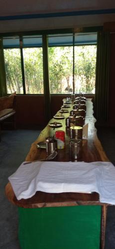 Una mesa larga está alineada en una habitación. en Corbett Nature Retreat, en Rāmnagar