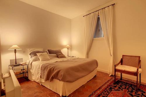 - une chambre avec un lit, une chaise et une fenêtre dans l'établissement LE LIMAS - CHARME - WiFI - PATIO - RDC, à Avignon