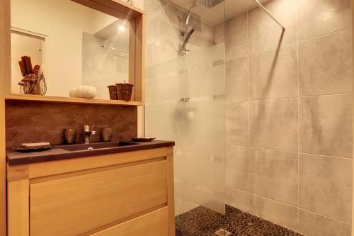 La salle de bains est pourvue d'un lavabo et d'une douche. dans l'établissement LE LIMAS - CHARME - WiFI - PATIO - RDC, à Avignon