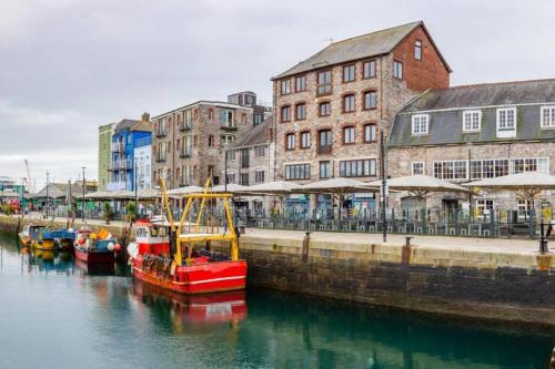 a group of boats docked in a harbor with buildings at Quay33 Deluxe Apartment, Barbican, Plymouth in Plymouth