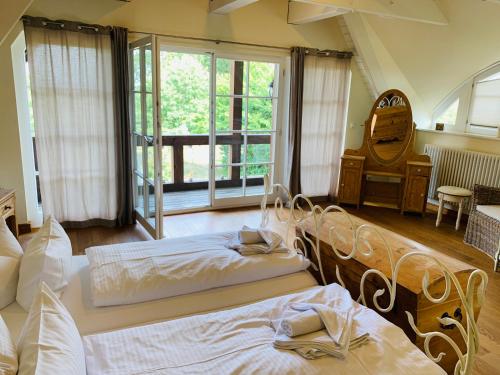 a bedroom with two beds and a large window at Landhaus am Achterwasser mit Bootssteg in Grüssow