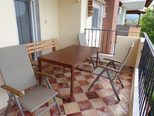 a wooden table and chairs on a balcony at Makis Nest Apart-Hotel in Vourvourou