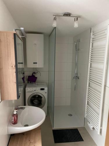 a bathroom with a sink and a washing machine at Wohnen im ehemaligen Kloster in Schörfling am Attersee in Schörfling