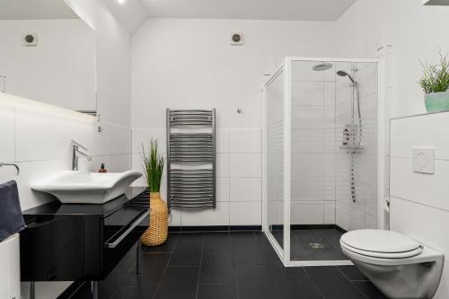 Baño blanco con lavabo y aseo en City-Apartment direkt in den Parkanlagen en Bremen