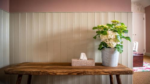 a table with a vase with a plant on it at The White Lion Cowbridge in Cowbridge