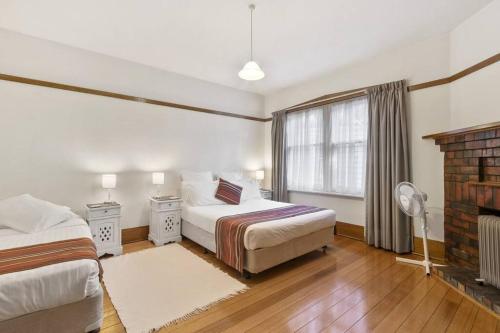 サンディ・ベイにあるHouse on Princesのベッド2台と窓のある寝室