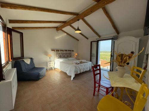 ein Wohnzimmer mit einem Bett, einem Tisch und Stühlen in der Unterkunft Panoramic Loft con uso cucina,Casa Placida - Ammentos in Posada
