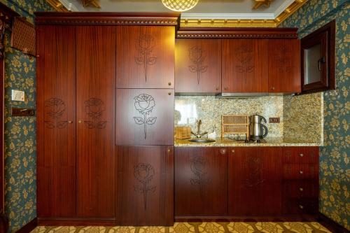 a kitchen with wooden cabinets in a room at The First Ottoman Apartments in Istanbul