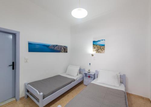 1 dormitorio con 2 camas y ventana en SantoriniNY, en Perissa