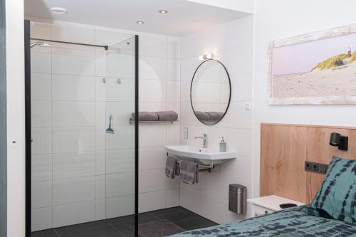 een badkamer met een douche en een wastafel bij Texbed in Den Burg