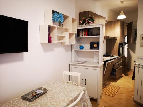 a small kitchen with a table and a tv on the wall at Alfieri home holiday in Rome