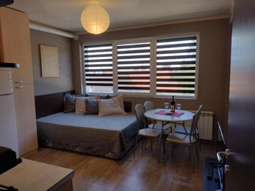 a bedroom with a bed and a table with chairs at All Seasons Apartments Iglika 2 in Borovets
