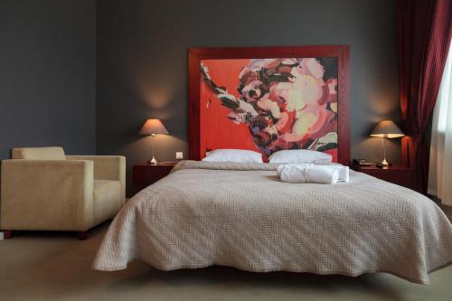 Un dormitorio con una cama con un cuadro en la pared. en Hotel Navalis, Klaipėda, en Klaipėda