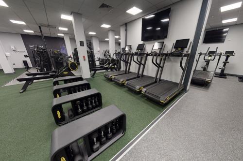 a gym with rows of treadmills and machines at Village Hotel Swindon in Swindon