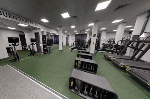 a gym with rows of treadmills and machines at Village Hotel Swindon in Swindon