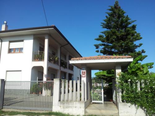 
a house with a fence and a building behind it at B&B La Casa di Angelica in Roseto degli Abruzzi
