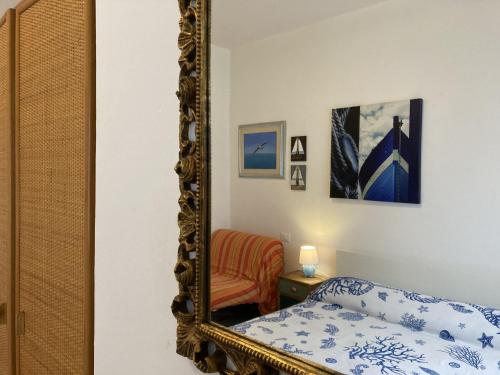een spiegel in een slaapkamer met een bed en een stoel bij Romea in Rosolina Mare