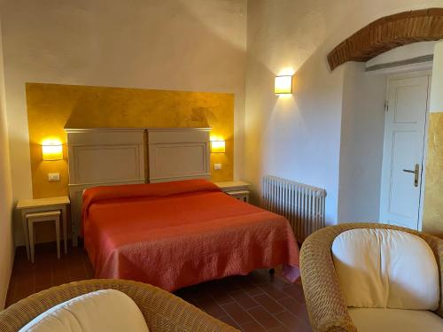 sypialnia z łóżkiem i krzesłem w pokoju w obiekcie Villa Terme Di Caldana B&B w mieście Venturina Terme