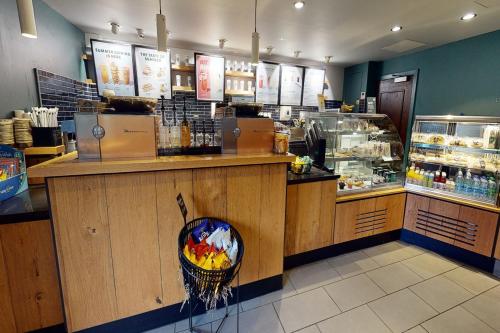 a restaurant with a counter with a bowl of food at Village Hotel Swindon in Swindon
