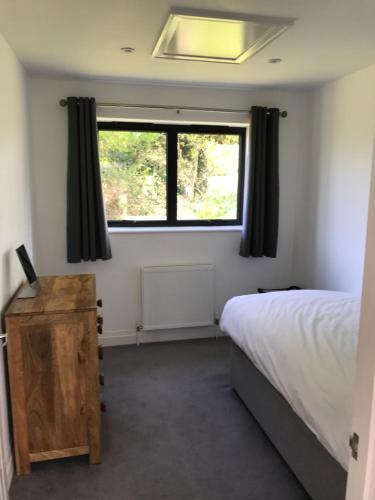 a bedroom with a bed and a window at The Old Flower Field in Hurstpierpoint