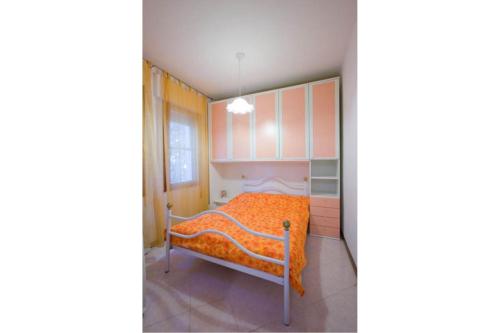 1 dormitorio con 1 cama con manta naranja en Serena, en Rosolina Mare