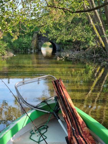 a boat on a river with a tunnel in the background at Przystań Piława in Borne Sulinowo