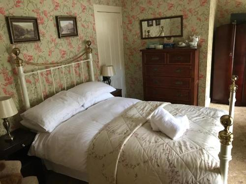 a bedroom with a bed and a dresser at Basil Sheils B&B Accommodation Armagh in Armagh