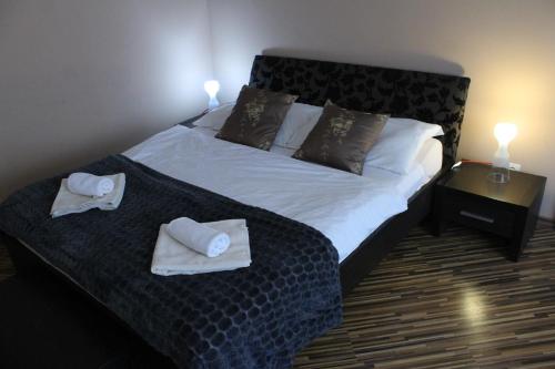 a bedroom with a bed with towels on it at Penzión Hellene in Piešťany