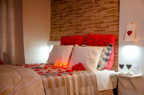 a bedroom with a bed with a love sign on it at Recanto Meu Pedacinho de Chão in Visconde De Maua