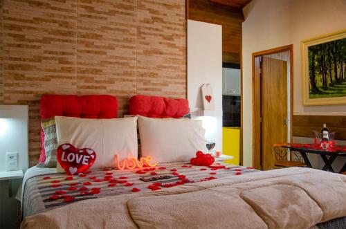 a bed with a bunch of red hearts on it at Recanto Meu Pedacinho de Chão in Visconde De Maua