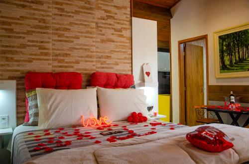 a bedroom with a bed with red roses on it at Recanto Meu Pedacinho de Chão in Visconde De Maua