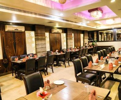 a dining room with tables and chairs in a restaurant at Simran Heritage(Business Hotel in Raipur