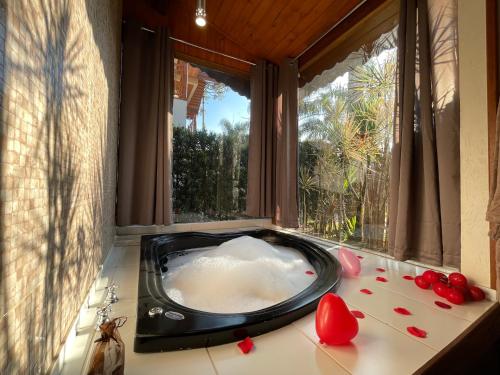 a bath tub sitting in a room with a window at Recanto Meu Pedacinho de Chão in Visconde De Maua