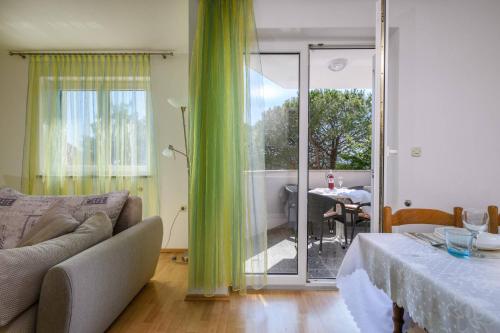 a living room with a couch and a sliding glass door at Apartment Matej in Rabac