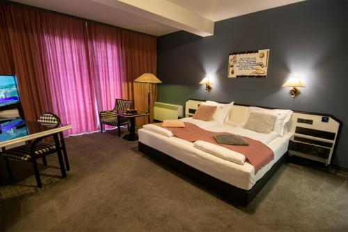 a bedroom with a large bed and a television at La Conacul Vesel Săpânța in Săpînţa