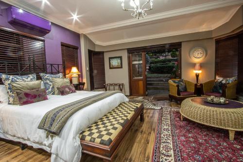 a bedroom with a large bed and a living room at The Tuscan Garden in Newcastle