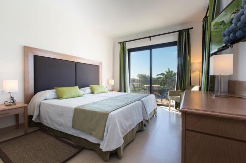 a bedroom with a large bed and a television at Sa Bassa Plana in Cala Pi
