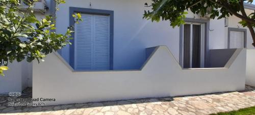 a blue window on a white house at Xuxi Apartments in Lukovë
