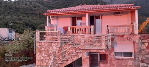 a stone house with a balcony on top of it at Xuxi Apartments in Lukovë